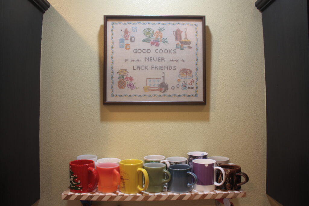 Mugs on kitchen shelf. Rainbow organization. Small house living.